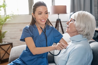 caring-nurse-using-stethoscope-while-examining-retired-woman