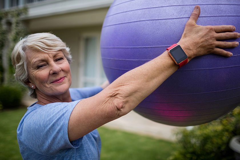 Senior woman exercising with fitness ball